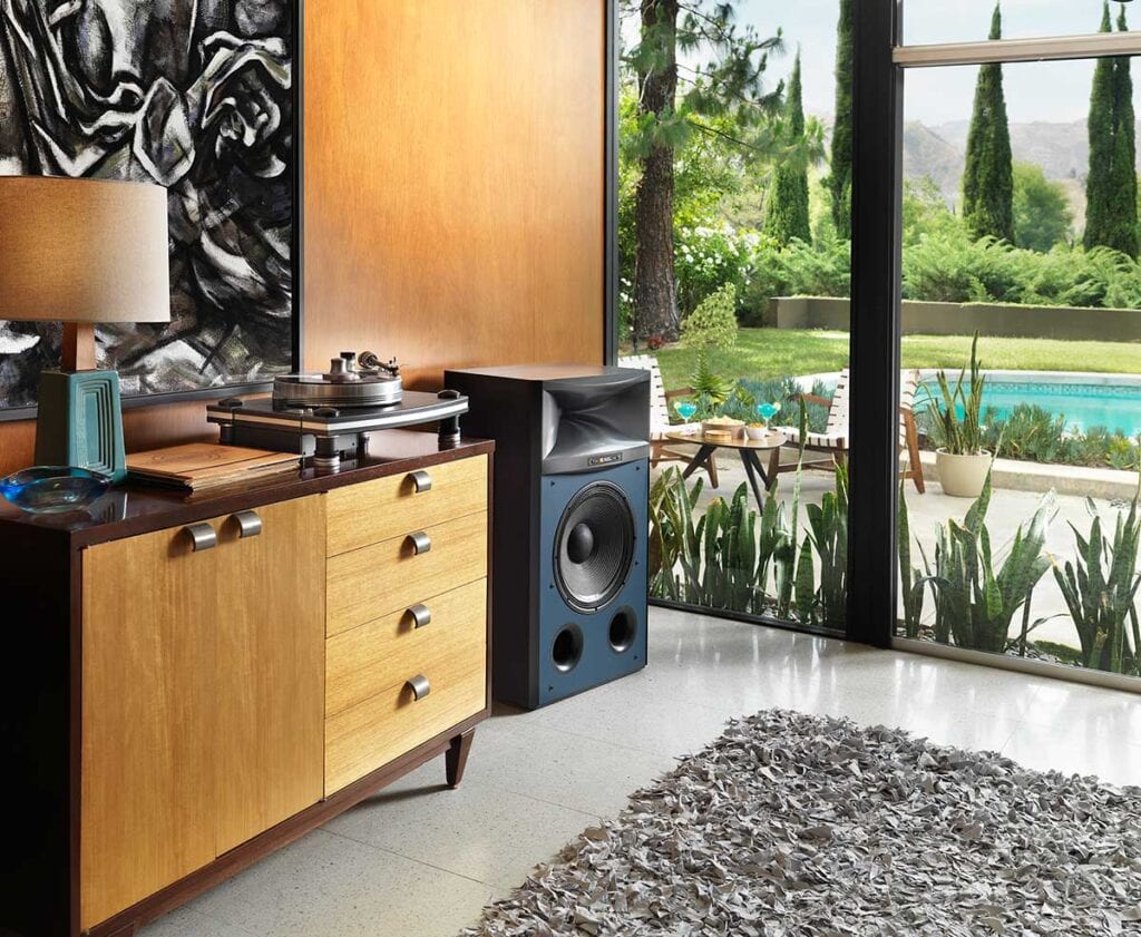 Turntable on top of a wood cabinet next to a speaker 