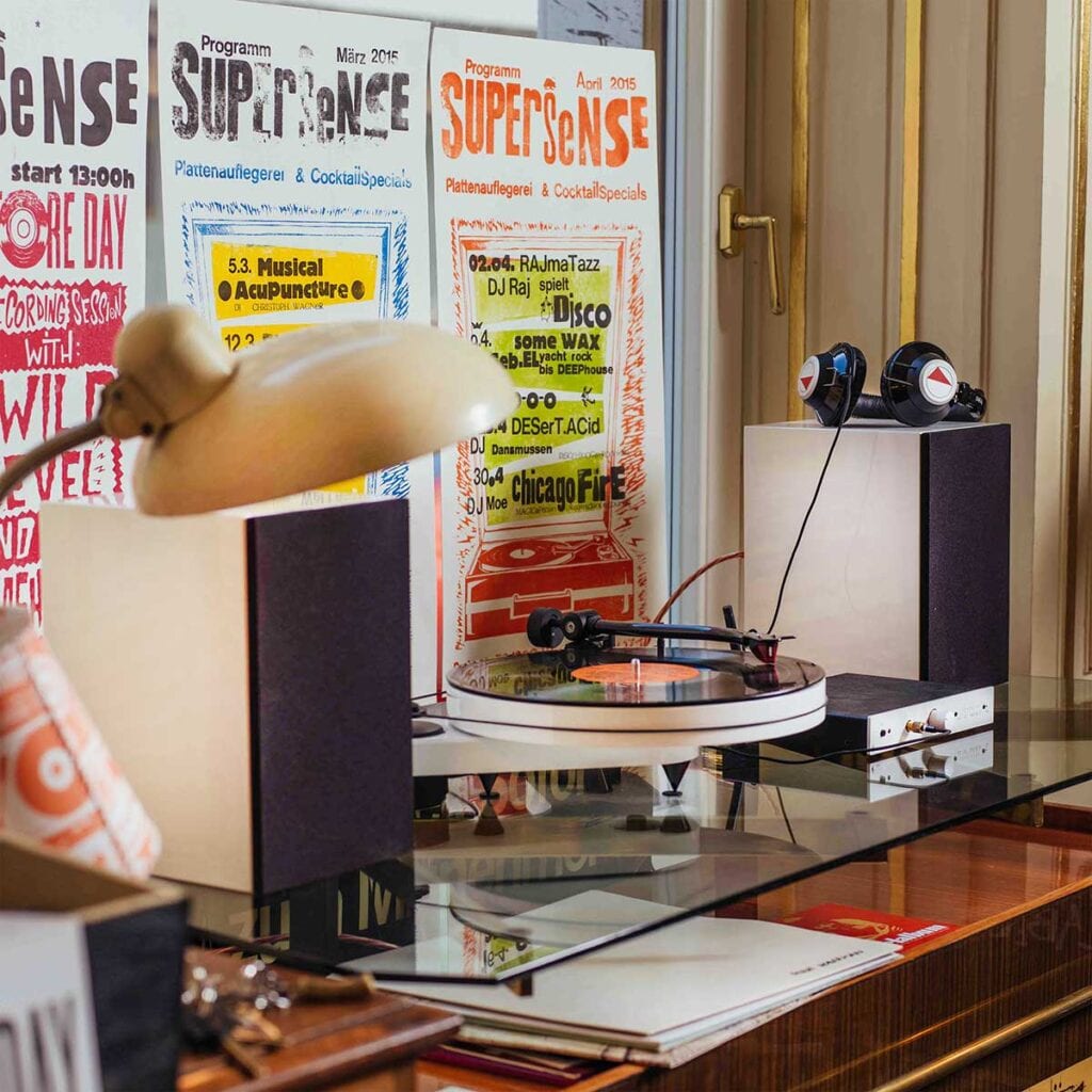 Turntable and bookshelf speakers on top of a glass topped desk