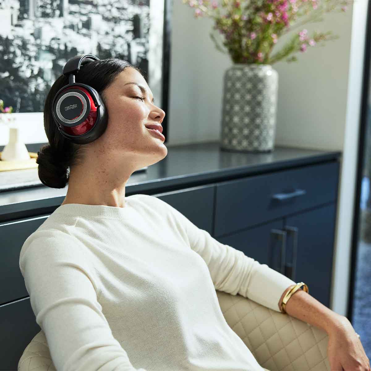 Female model wearing a pair of Mark Levinson № 5909 Premium Hi-Res Wireless ANC Over-Ear headphones while enjoying reference-class sound quality.