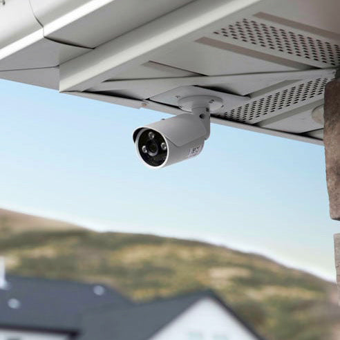 Security camera mounted under the eaves of a roof