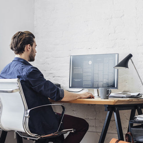 A man sitting at a desk work on a computer