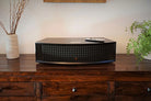 JBL L42ms Integrated Music System in black on a wooden shelf