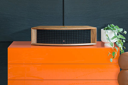 JBL L75ms Music System in walnut on an orange shelf