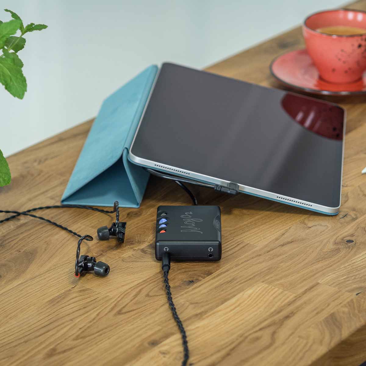 Chord Mojo 2 sitting on white pedestal with status lights illuminated