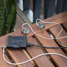 Chord Mojo 2 connected to  tablet and in-ear headphones sitting on desk