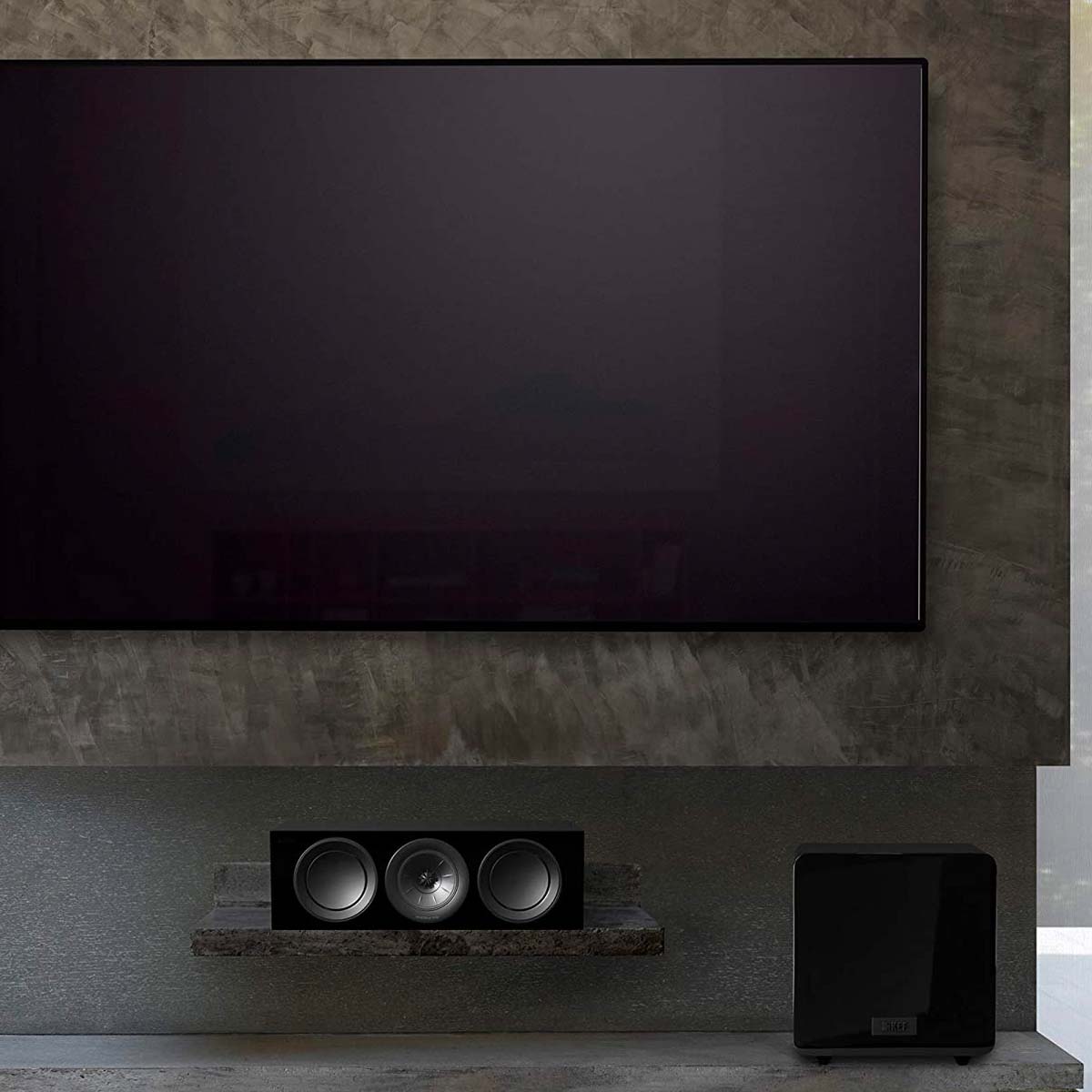 KEF KF92 1000W Dual 9 Inch Force Canceling with iBX - Gloss Black - Each - in room with TV and center channel speaker