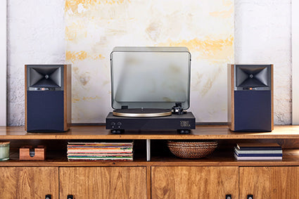 JBL Spinner Turntable on a console table between a set of speakers