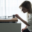 Pro-Ject X1B True Balanced Turntable - Gloss Black - on table with female lowering tonearm