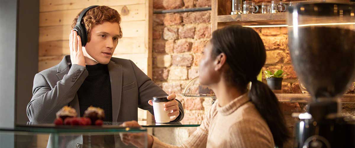 A man using Quick Attention Mode with Sony WH-1000XM4 to speak to a barista